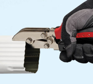 Gloved hand crimping a white gutter downspout with Malco's 5-blade C4R tool