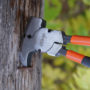 Malco Multi Purpose Fencing Plier being used to pull out nails on a wooden post