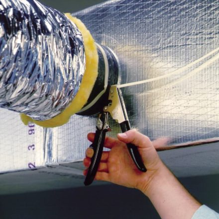 Person using Malco's TY6 tool to tension a nylon tie to fiberglass duct