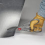 Worker with gloves cutting a piece of sheet metal with Malco's M12A Andy Classic Snip