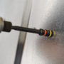 A screw being fastened to a piece of sheet metal with a Malco 7 and 8 MM CRHEX