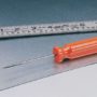An orange Malco Scratch awl on a piece of sheet metal next to a silver ruler