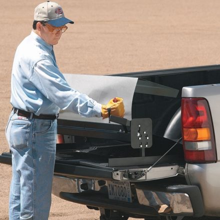 Man using Malco's Portable Sheet Metal Brake on back of truck